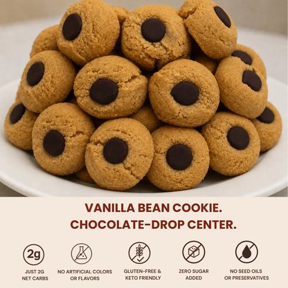 A pile of vanilla bean cookies with chocolate chip centers on a white plate, with text below reading 'VANILLA BEAN COOKIE. CHOCOLATE-DROP CENTER.