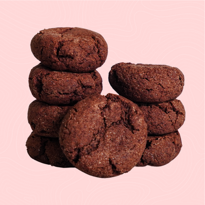 A stack of rich, sugar-free chocolate cookies with a soft, crumbly texture, set against a light pink background. A decadent treat perfect for chocolate lovers seeking a guilt-free indulgence.